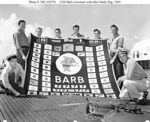Załoga USS Barb z banderą w sierpniu 1945 roku. Zdjęcie wykonane po zakończeniu 12 patrolu. / Zdjęcie: en.wikipedia.org