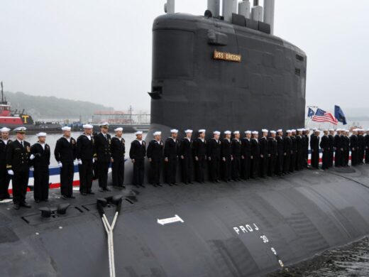 Członkowie załogi dołączeni do okrętu podwodnego USS Oregon typu Virginia przejmują okręt podczas ceremonii przekazania do eksploatacji w Groton w stanie Connecticut. Źródło: zdjęcie Marynarki Wojennej USA wykonane przez głównego podoficera Joshuę Karstena.
